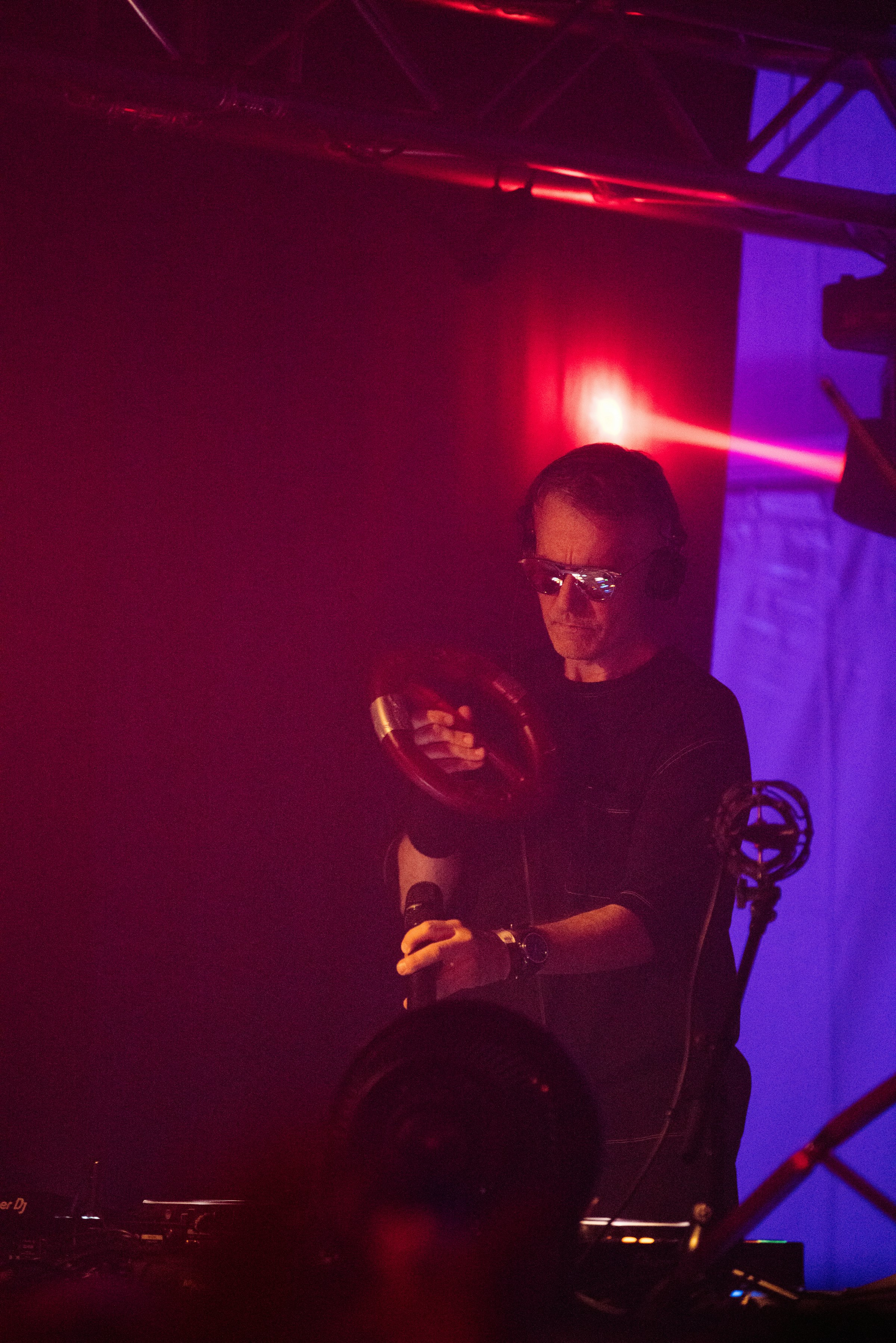 A performer on stage with a tambourine and microphone by Florian Schindler